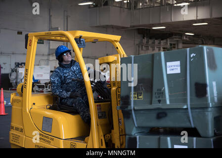 NORFOLK, Virginie (Mar. 14, 2018) 1ère classe Ordnanceman Aviation Simon Hernandez opère un chariot élévateur dans le hangar bay lors d'une sur-charge d'armes à bord de l'USS Harry S. Truman (CVN 75). Truman est actuellement amarré à la Naval Station Norfolk préparatifs de déploiement. Banque D'Images