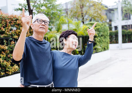Happy senior Asian couple walking et orientée en parc extérieur et de la chambre Banque D'Images