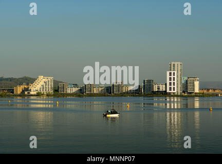 Vue paysage d'un petit bateau de pêche sur les eaux calmes de la baie de Cardiff au début de lumière du matin. Les appartements sont au bord de l'eau dans l'arrière-plan Banque D'Images