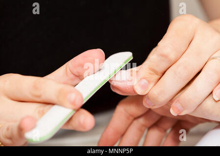 L'esthéticienne polish les ongles de la cliente avant de mettre du vernis à ongles Banque D'Images