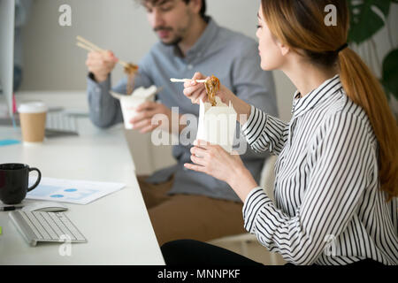 Bureau gens eating chinese food en boîte de nouilles pendant le déjeuner Banque D'Images