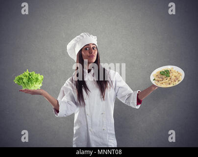 Chef indécis entre une salade fraîche ou un plat de pâtes Banque D'Images