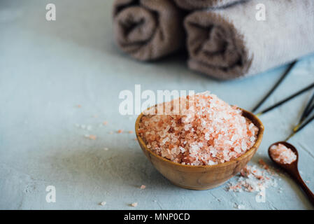 Bol en bois avec du sel rose sur fond neutre Banque D'Images