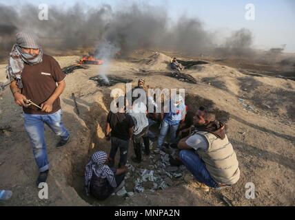 La bande de Gaza. 18 mai, 2018. Des manifestants palestiniens affrontent avec des soldats israéliens à l'est de Gaza près de la frontière avec Israël le 18 mai 2018. Des dizaines de manifestants palestiniens ont été blessées vendredi par des tirs de l'armée israélienne et des gaz lacrymogènes lors des affrontements, medecins dit. Credit : Wissam Nassar/Xinhua/Alamy Live News Banque D'Images