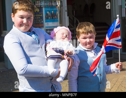 Christchurch, Bournemouth, Dorset, UK. 19 mai 2018. Les clients arrivent en tenue de mariage, avec un prix pour la meilleure habillé, à l'art déco, le Regent Cinema Center, l'un des plus beaux exemples d'un début des années 30, le cinéma pour survivre en Grande-Bretagne, à Christchurch, Dorset. Le Centre est l'hôte d'un régent en direct de l'action du mariage royal, montrant les invités arrivant à 10 h 30 et la cérémonie elle-même à midi quand le prince Harry et Meghan Markle le faire et de se marier. Les jeunes supporters royale vêtus de leurs plus beaux atours holding baby princess. Banque D'Images