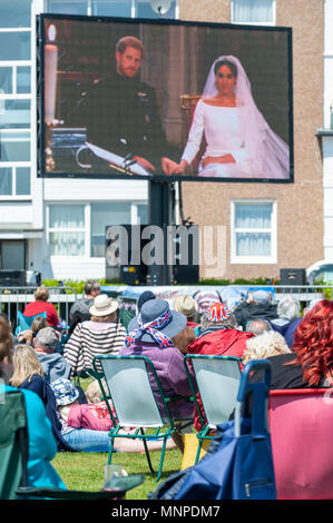 Les gens regardent le prince Harry et Meghan Markle's wedding sur grand écran à un événement de mariage royal à Bexhill on Sea dans l'East Sussex, Angleterre. Banque D'Images