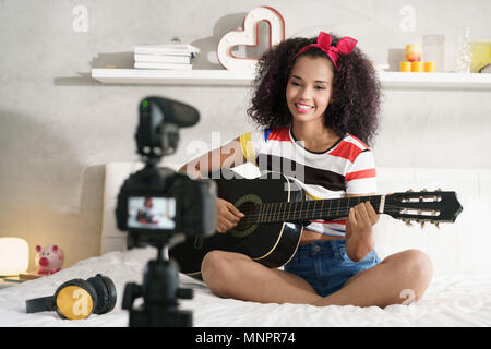 Femme Girving classe de guitare sur Internet avec le tutoriel vidéo Banque D'Images