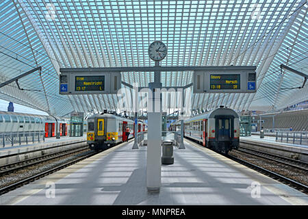 L'équilibre de l'architecture symétrique de transports publics moderne Liège Belgique EU gare quai de gare l'horloge et le grand toit en verre couvrant les trains Banque D'Images