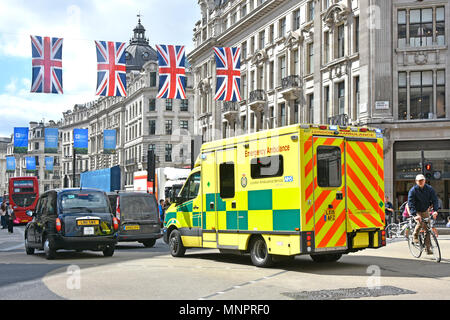 Scène de rue London NHS ambulance d'urgence dans la région de Oxford Circus embouteillage attendre d'entrer dans la rue Regent vélo cycliste à la sortie West End Union jack UK Banque D'Images