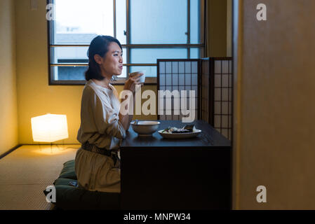 Asian woman eating dans un appartement traditionnel japonais à Tokyo Banque D'Images