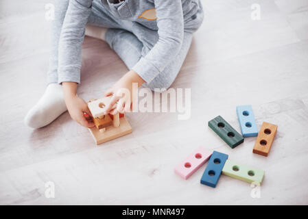 Les enfants jouent avec un créateur de jouets sur le plancher de la chambre des enfants. Deux enfants qui jouent avec des blocs colorés. Jeux éducatifs maternelle Banque D'Images