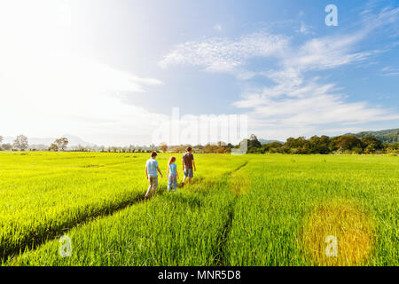 Famille du père et de deux enfants bénéficiant d'promenade tranquille dans les rizières avec une vue imprenable sur les montagnes au Sri Lanka Banque D'Images