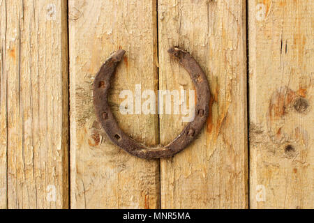 Old rusty à cheval sur un mur en bois Banque D'Images
