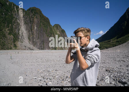 Un adolescent prendre des photos lors d'un glacier en Nouvelle Zélande Banque D'Images