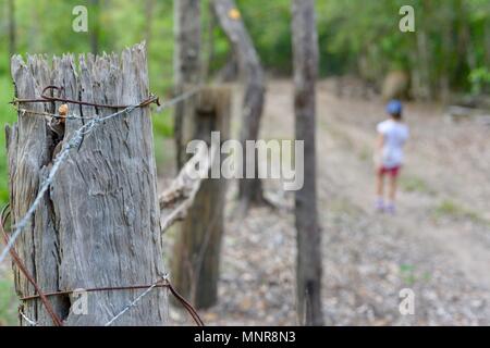 Les gens en passant devant une vieille en décadence et mangé par les termites, poteau de clôture Rollingstone France Banque D'Images