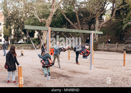 Lisbonne, Portugal 01 mai 2018 : Aire de jeux avec les enfants et les parents. Famille avec enfants ou père et mère avec des enfants on swing Banque D'Images