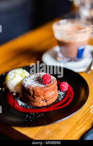 Délicieux dessert fondant au chocolat servi avec glace vanille et fruits frais Banque D'Images