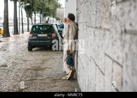 Lisbonne, Portugal 01 mai 2018 : près de l'homme mur sur trottoir attend. La rue piétonne ou sur le tourisme et l'attente ou de repos ou à pied. Banque D'Images