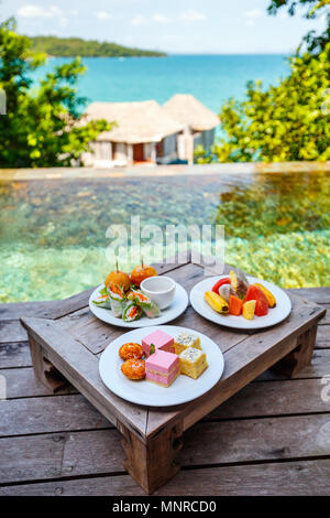 Service en chambre délicieux déjeuner des hamburgers, des fruits et des bonbons servis sur une table proche piscine Banque D'Images