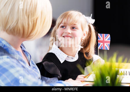 Jolie jeune fille qui étudient le français langue avec elegant blonde femme éducatrice Banque D'Images