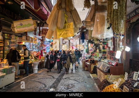 Shoppers marcher le long de rues étroites bordées de boutiques vendant une variété de produits et d'épices, Istanbul, Turquie Banque D'Images