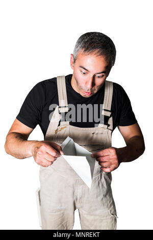 Surpris mâle homme plombier spécialiste, ingénieur ou d'un constructeur en blanc sale minable vieux costume de travail, t-shirt noir regarder à l'intérieur une lette vide Banque D'Images