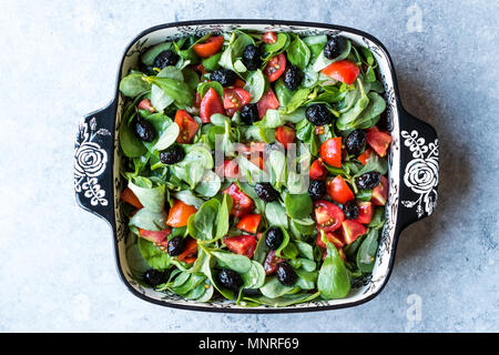 Le pourpier salade avec tomates et olives noires en Bol en porcelaine. L'alimentation biologique. Banque D'Images