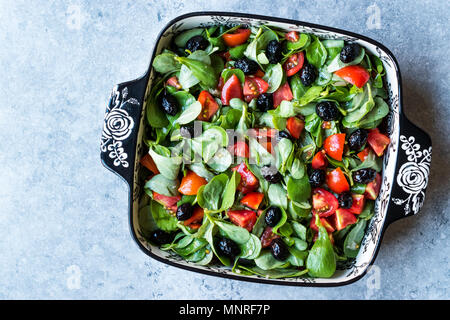 Le pourpier salade avec tomates et olives noires en Bol en porcelaine. L'alimentation biologique. Banque D'Images