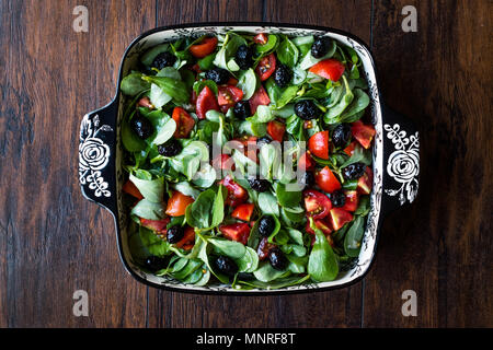 Le pourpier salade avec tomates et olives noires en Bol en porcelaine. L'alimentation biologique. Banque D'Images