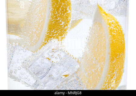 Dans un verre avec des cubes de glace fondante tranches d'un citron juteux. Banque D'Images