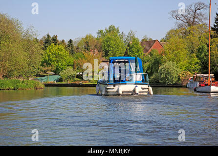 Un croiseur sur la rivière Bure sur les Norfolk Broads à Belaugh, Norfolk, Angleterre, Royaume-Uni, Europe. Banque D'Images