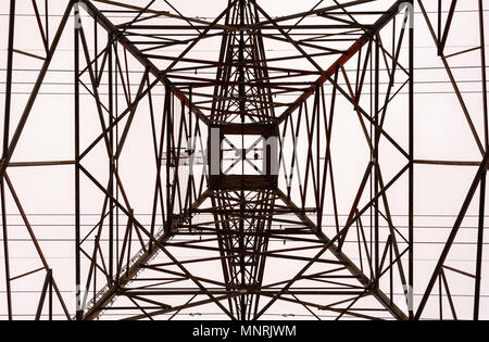 Jusqu'à la recherche sur l'intérieur de la grande tour de transmission électrique métal frame en perspective contre ciel couvert. Banque D'Images