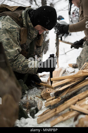 1er lieutenant Timothy Turner, 23e Escadron d'entraînement en vol de l'UH-60 pilote et séré étudiant, se divise en bois avec un couteau pendant la formation à l'École de survie de l'Armée de l'air dans la zone d'entraînement Cusick, Washington, le 18 février 2018. Le processus de création d'un incendie peuvent se réchauffer la personne ainsi. C'est enseigné que plus vous travaillez, le plus chaud que vous obtenez. Banque D'Images