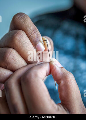 Woman putting thread dans l'aiguille Banque D'Images