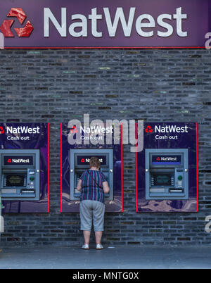 Woman withdrawing cash de Natwest Distributeurs automatiques à Londres Banque D'Images