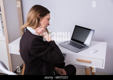 Femme d'âge mûr souffrant de douleur au cou dans Office Banque D'Images