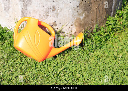 Arrosoir jaune en plastique on Green grass in garden Banque D'Images