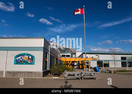 Extérieur du bâtiment de l'école intermédiaire Lawrence Grassi avec drapeau canadien et ligne d'horizon des montagnes Rocheuses Parc national Banff Canmore, Alberta Canada Banque D'Images