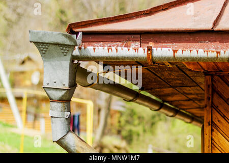 Des caniveaux à vieille maison en bois rustique et d'un système de drainage de l'eau du toit. Close-up. Banque D'Images