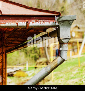 Des caniveaux à vieille maison en bois rustique et d'un système de drainage de l'eau du toit. Square. Close-up. Banque D'Images