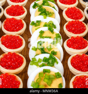 Des tartelettes avec du caviar rouge et noir et d'oeufs. Arrière-plan de l'alimentation. Concept d'aliment de luxe. Square. Close-up. Banque D'Images