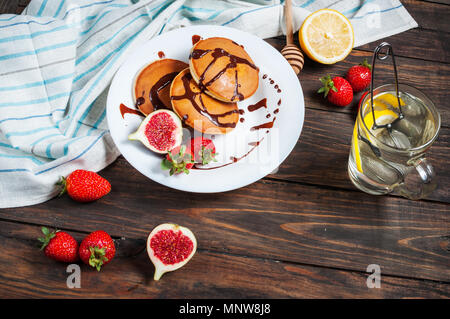 Tasse de thé et des pancakes aux figues, fraises sur plaque blanche libre. Banque D'Images