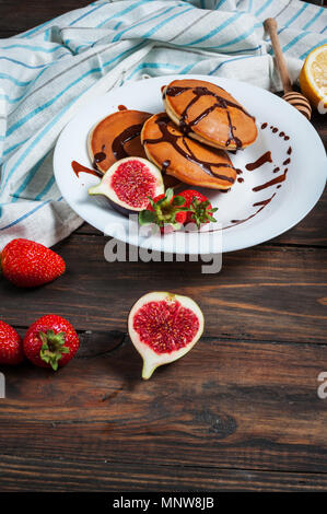 Pancakes aux figues, fraises sur plaque blanche libre. Banque D'Images