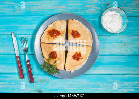 Des crêpes avec du caviar rouge sur la plaque. La cuisine russe. Maslenitsa Banque D'Images