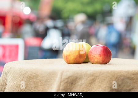 Trois multi-couleur des pommes mûres se situent sur une nappe texturé comme un symbole de la récolte au festival Banque D'Images