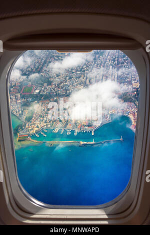 Vue aérienne par le biais de la fenêtre d'un avion de la belle ville de La Canée, avec son vieux port et son célèbre phare, Crète, Grèce. Banque D'Images