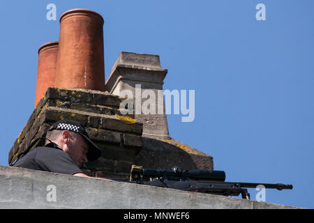 Windsor, Royaume-Uni. 19 mai, 2018. Une police sniper sur un toit au-dessus de la rue principale relève des milliers de sympathisants qui tapissent les rues de Windsor pour assister à la procession de chariot, le prince Harry et Meghan Markle, maintenant, le duc et la duchesse de Sussex après leur mariage à la Chapelle St George du château de Windsor. Credit : Mark Kerrison/Alamy Live News Banque D'Images