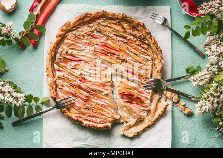 Gâteau à la rhubarbe . Prêt maison fraîchement sorti du pie à la rhubarbe sur fond bleu table de cuisine avec la fourche, vue du dessus. Cuisine de saison et la concep Banque D'Images