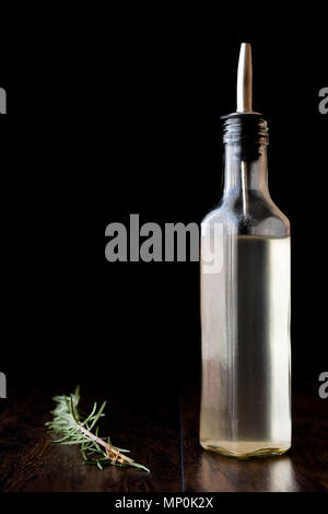 Vinaigre blanc en bouteille avec le romarin. L'alimentation biologique. Banque D'Images