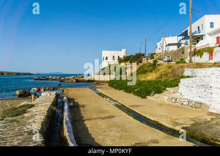 Les gens se baigner dans l'eau dans la plage de Loutra (bains)à Kythnos. L'eau de source chaude minérale qui coule à travers un canal et se mélange avec la mer Banque D'Images